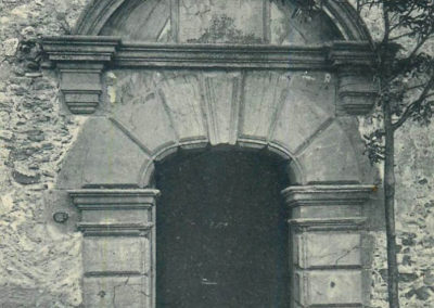 Photo ancienne d'une imposante porte dans un mur en pierre