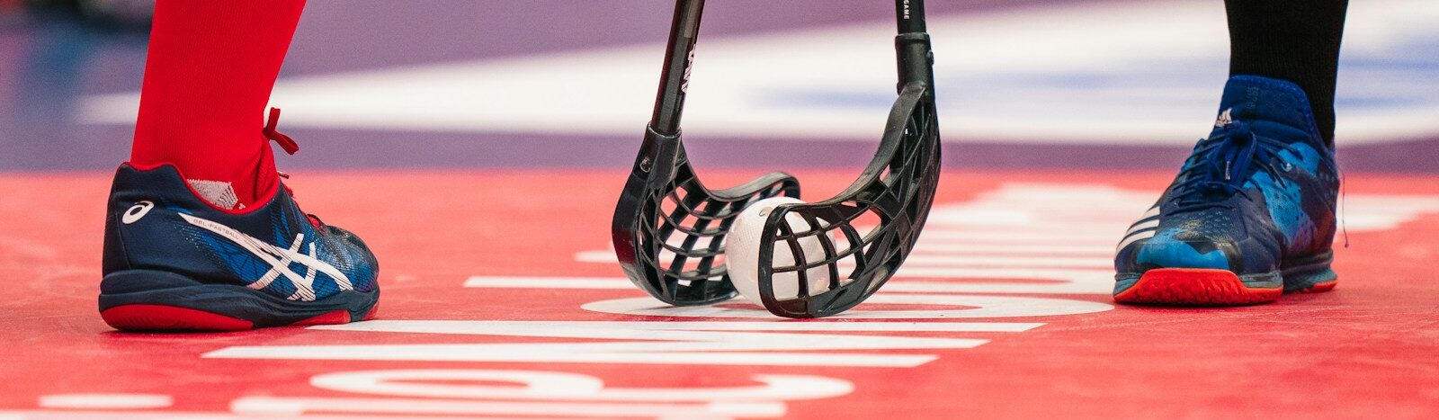 person in red pants wearing black and white nike sneakers